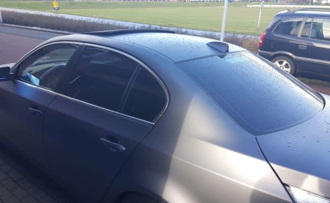 Matgrijze BMW 5-serie met getinte ramen